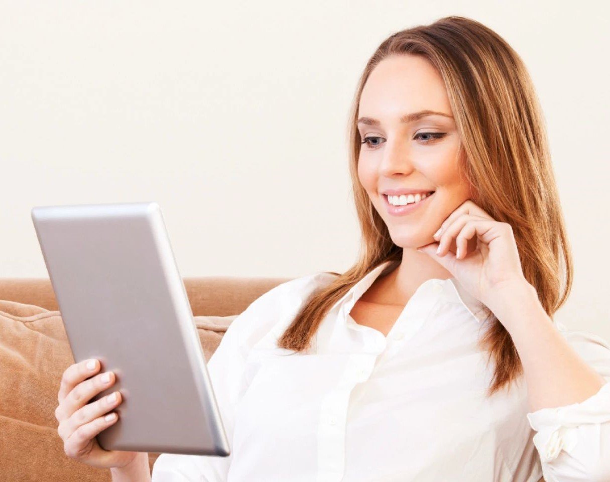 woman sitting on couch with tablet